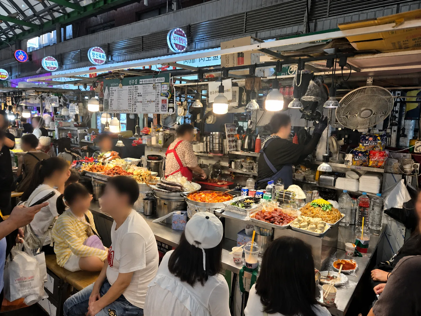 Busy street food stalls inside Gwangjang Market in Seoul