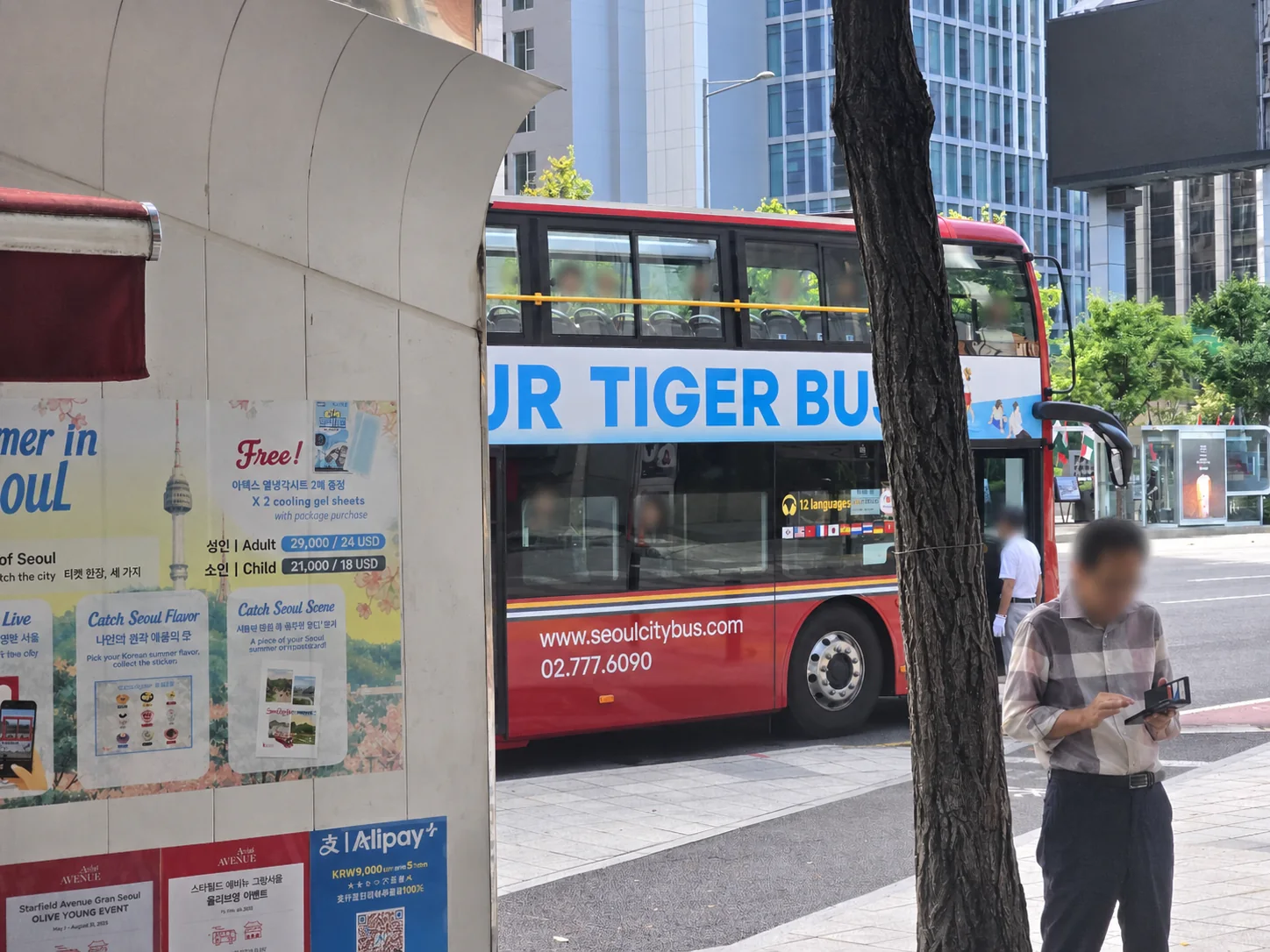 Red double-decker Seoul City Tour Tiger Bus beside the Gwanghwamun ticket booth