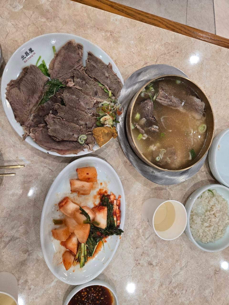 Bukchangok gomtang with sliced beef, kimchi and rice