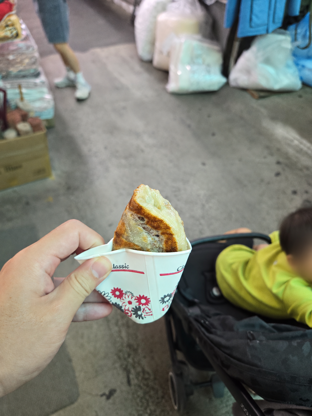 Chewy sweet hotteok in a paper cup at Namsan Kim Jin Ho Hotteok; child face blurred for privacy