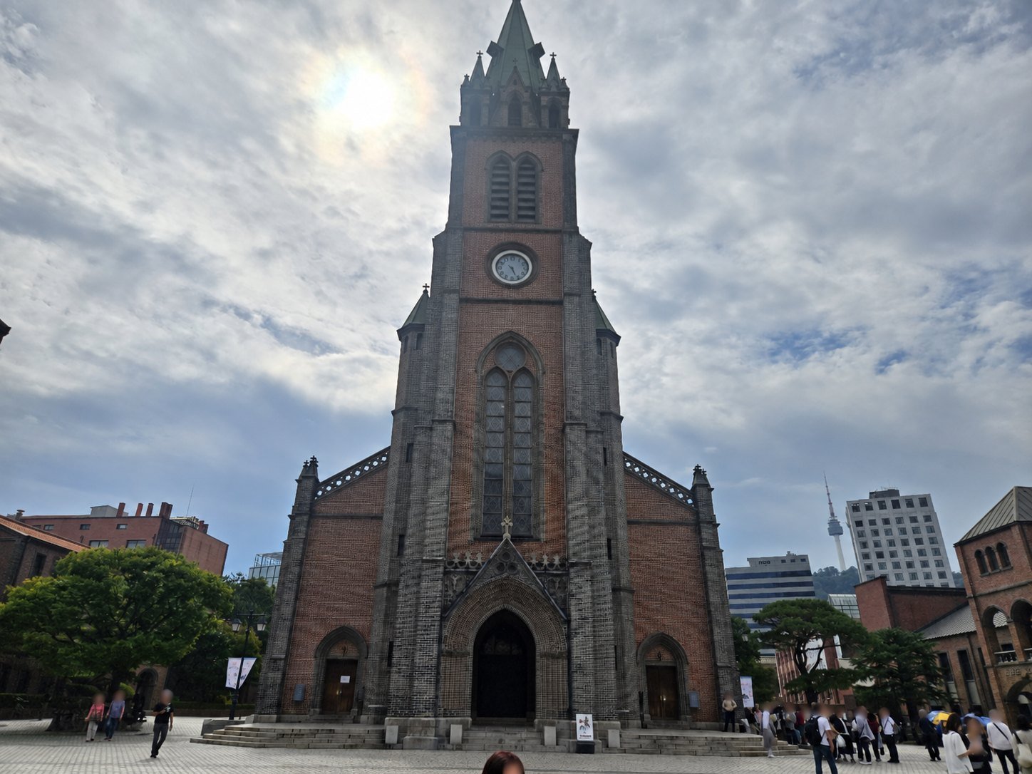 Myeongdong Cathedral front facade and bell tower under a cloudy Seoul sky