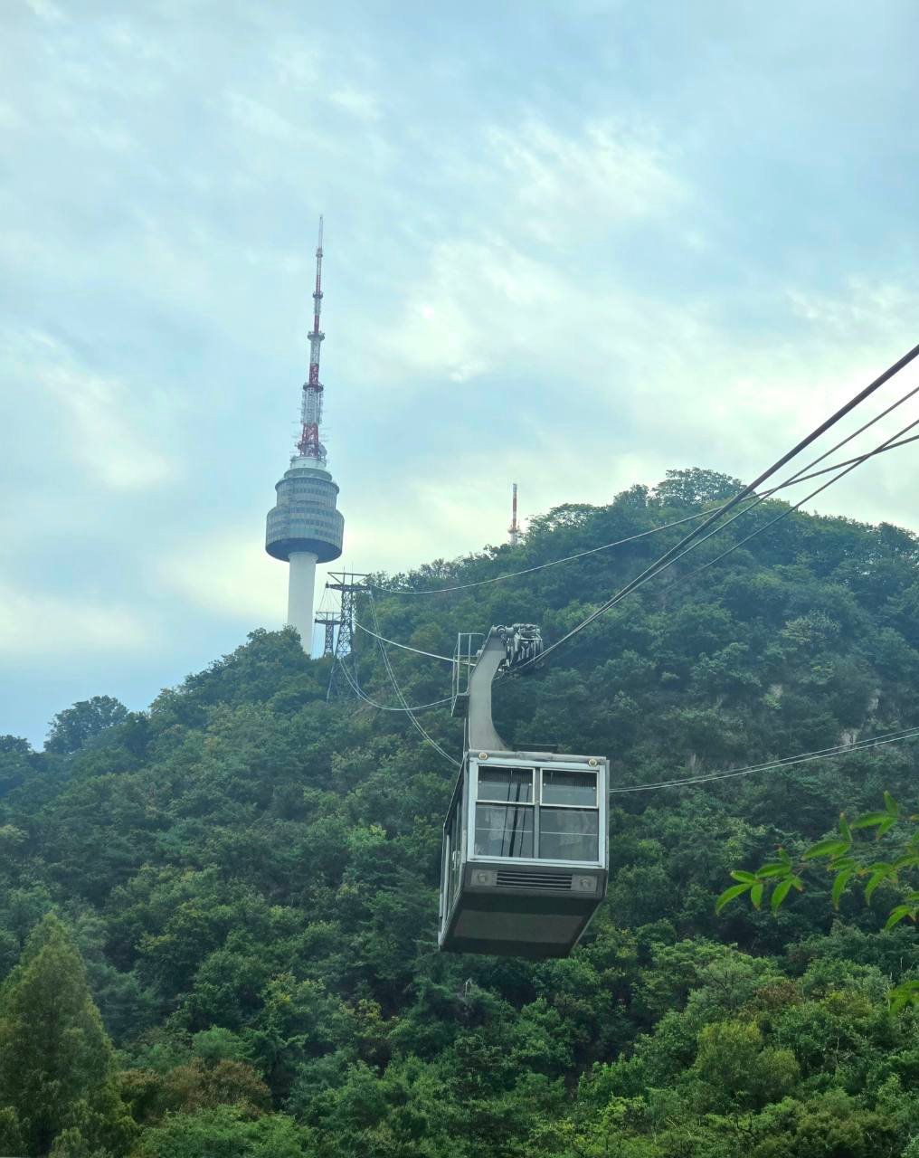 Namsan cable car climbing toward N Seoul Tower through the forest