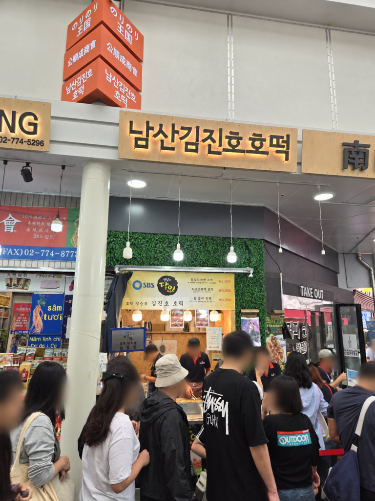 Namdaemun Vegetable Hotteok vs Namsan Kim Jin Ho Hotteok: Namsan Kim Jin Ho stall sign; faces blurred for privacy