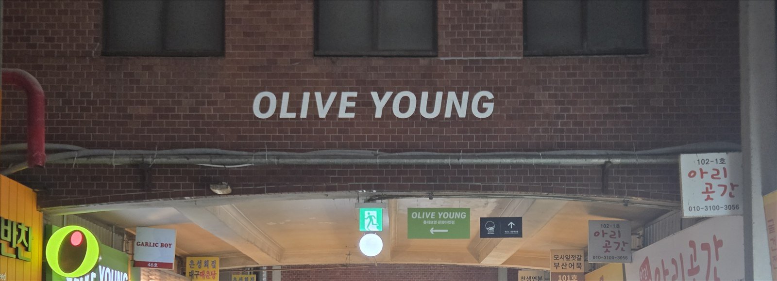 Olive Young sign and busy shopping corridor inside a Seoul market in Seoul