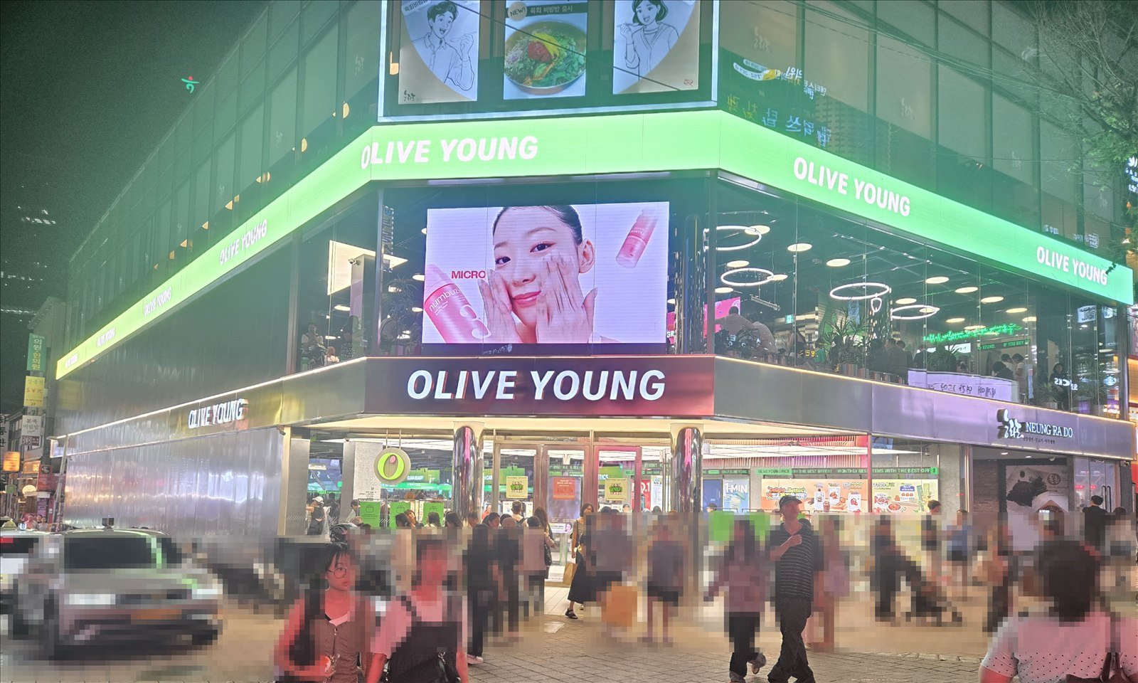Olive Young Myeongdong full storefront with the first-floor ground and entrance visible at night in Seoul