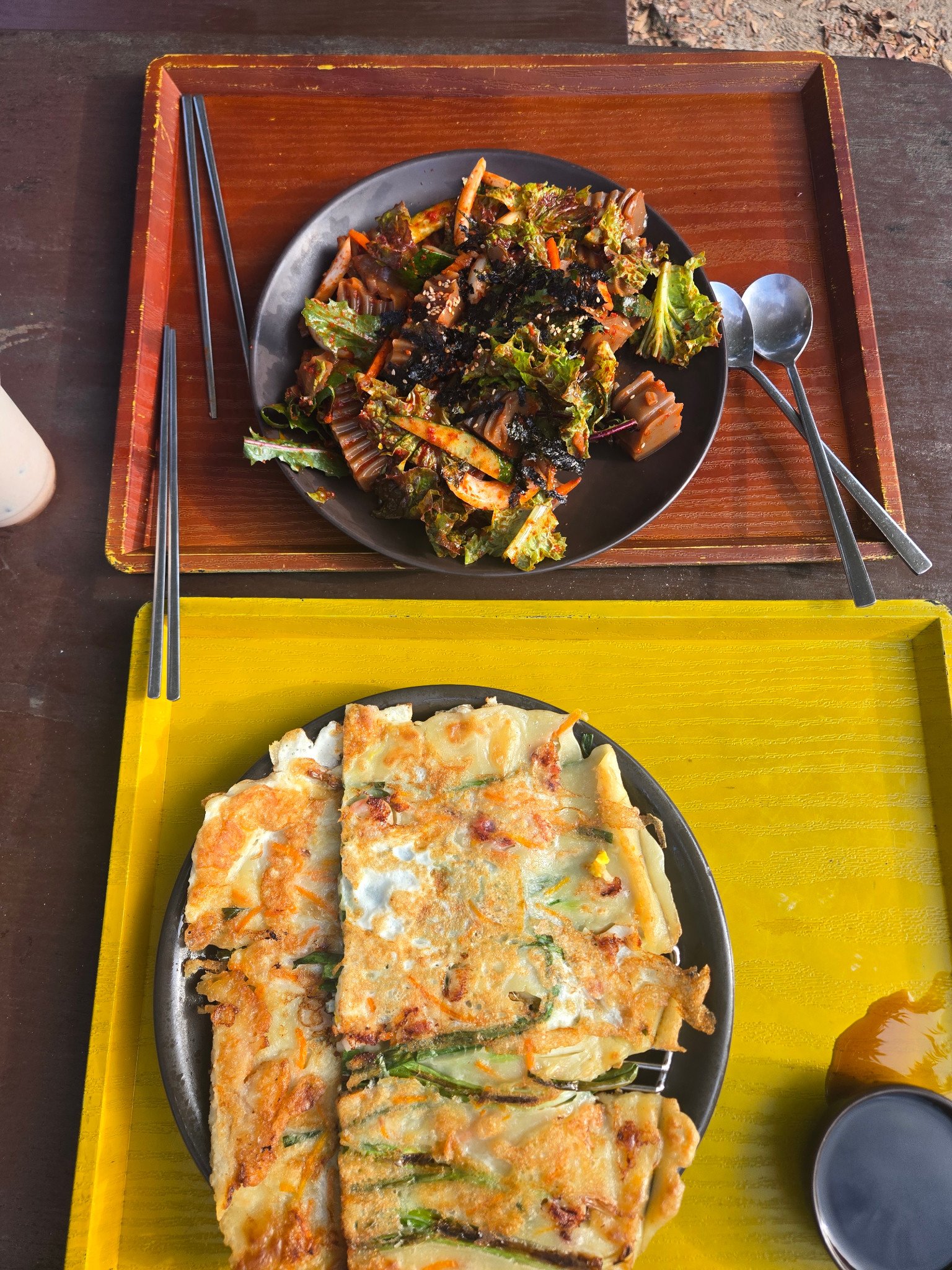 Pancake pieces and a dressed dish served on two trays at Korean Folk Village