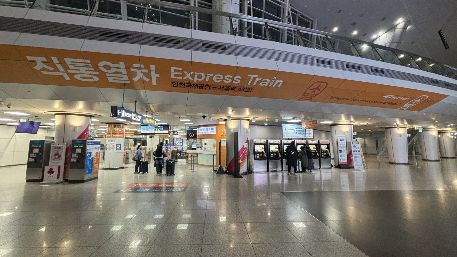 AREX Express Train concourse at Incheon Airport Terminal 1 with ticket machines and travelers carrying luggage