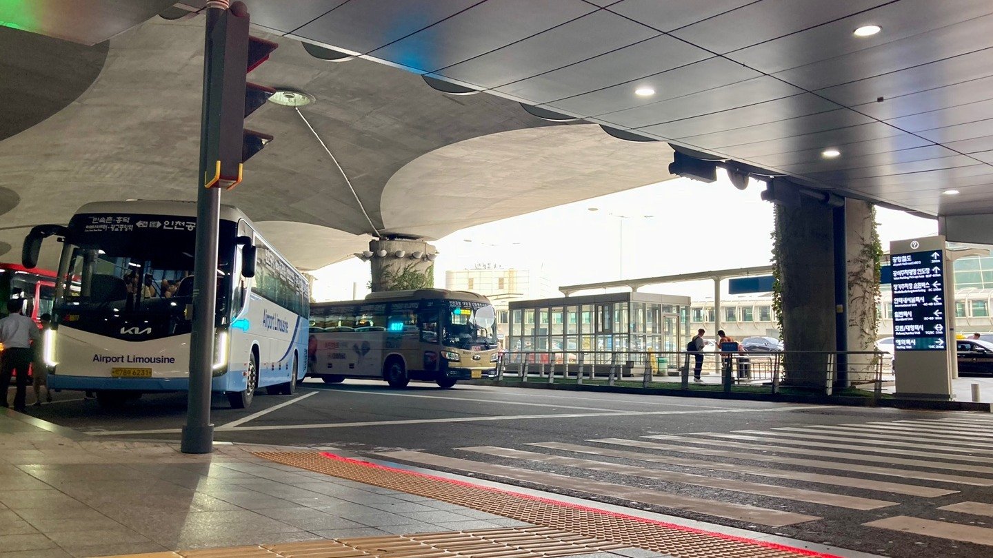 Airport limousine buses beside the curb and pedestrian crossing at Incheon Airport Terminal 1