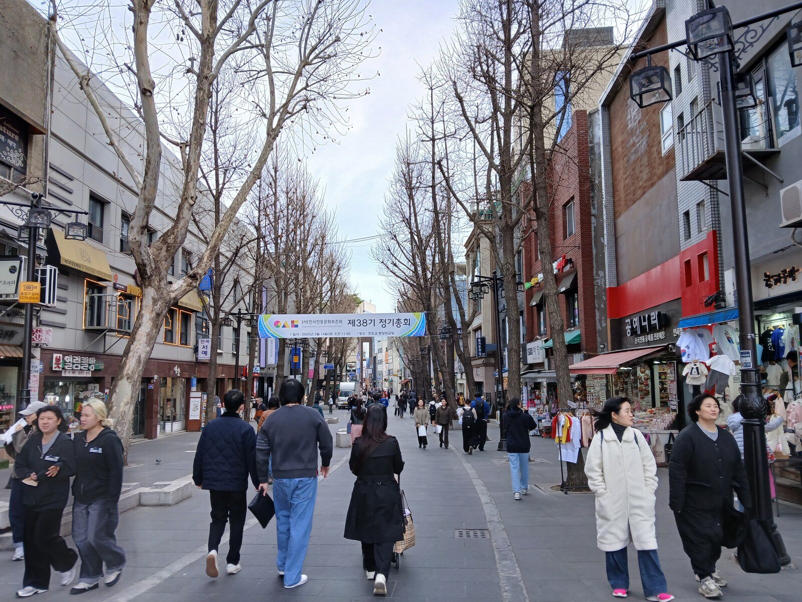 Pedestrians walking along Insadong-gil between craft and souvenir shops.
