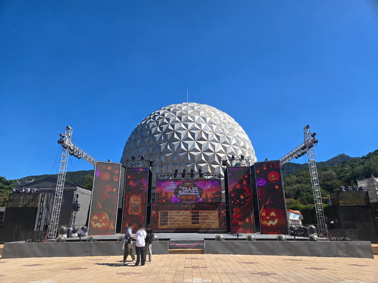 Daytime performance stage beneath Seoul Land’s geodesic dome with Halloween decorations