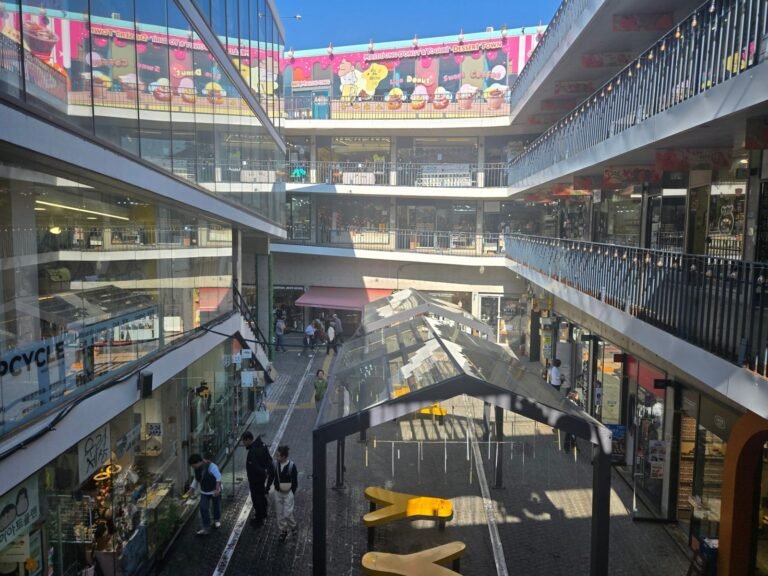 Ssamziegil courtyard in Insadong with sloping shop walkways, yellow benches and open sky