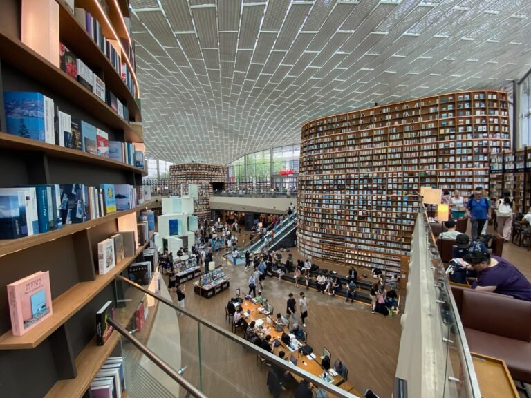 Tall bookshelves and visitors inside Starfield Library at COEX in Seoul