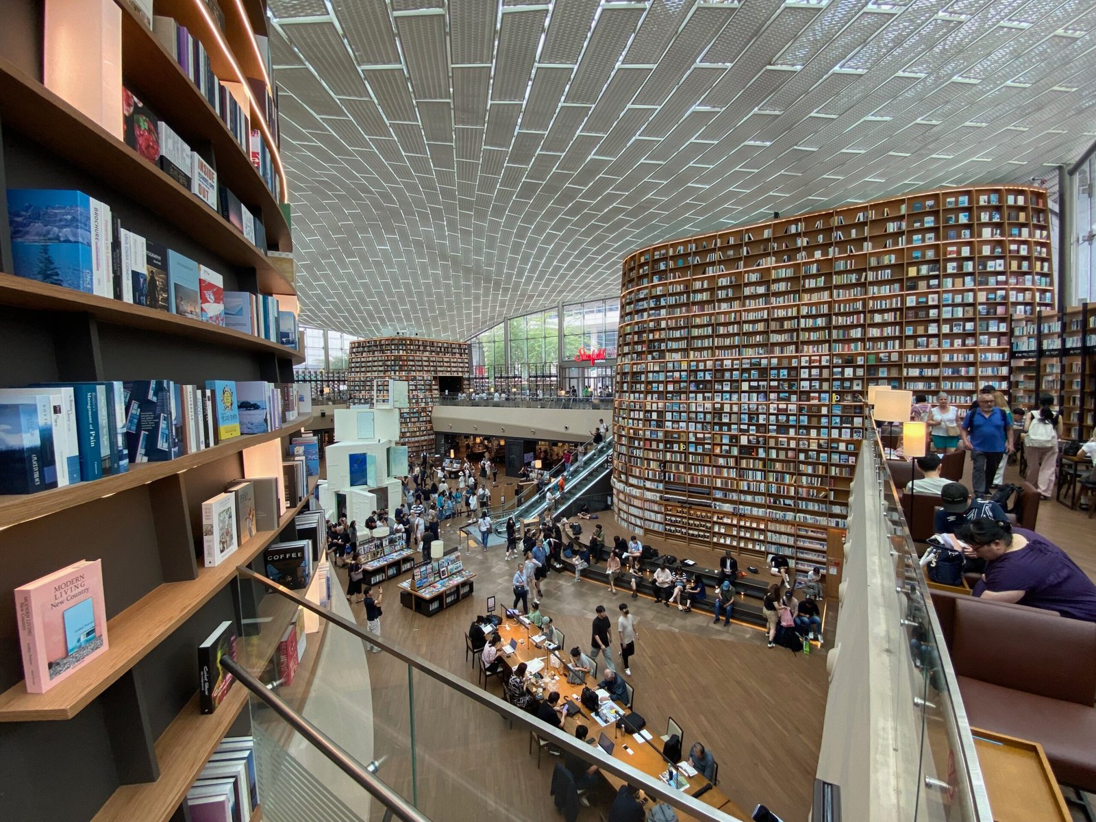 Tall bookshelves and visitors inside Starfield Library at COEX in Seoul